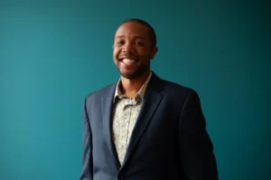 Kedrick Armstrong in a blue suit and yellow and blue paisley shirt.