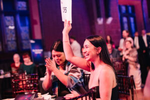 A woman raising an auction paddle.