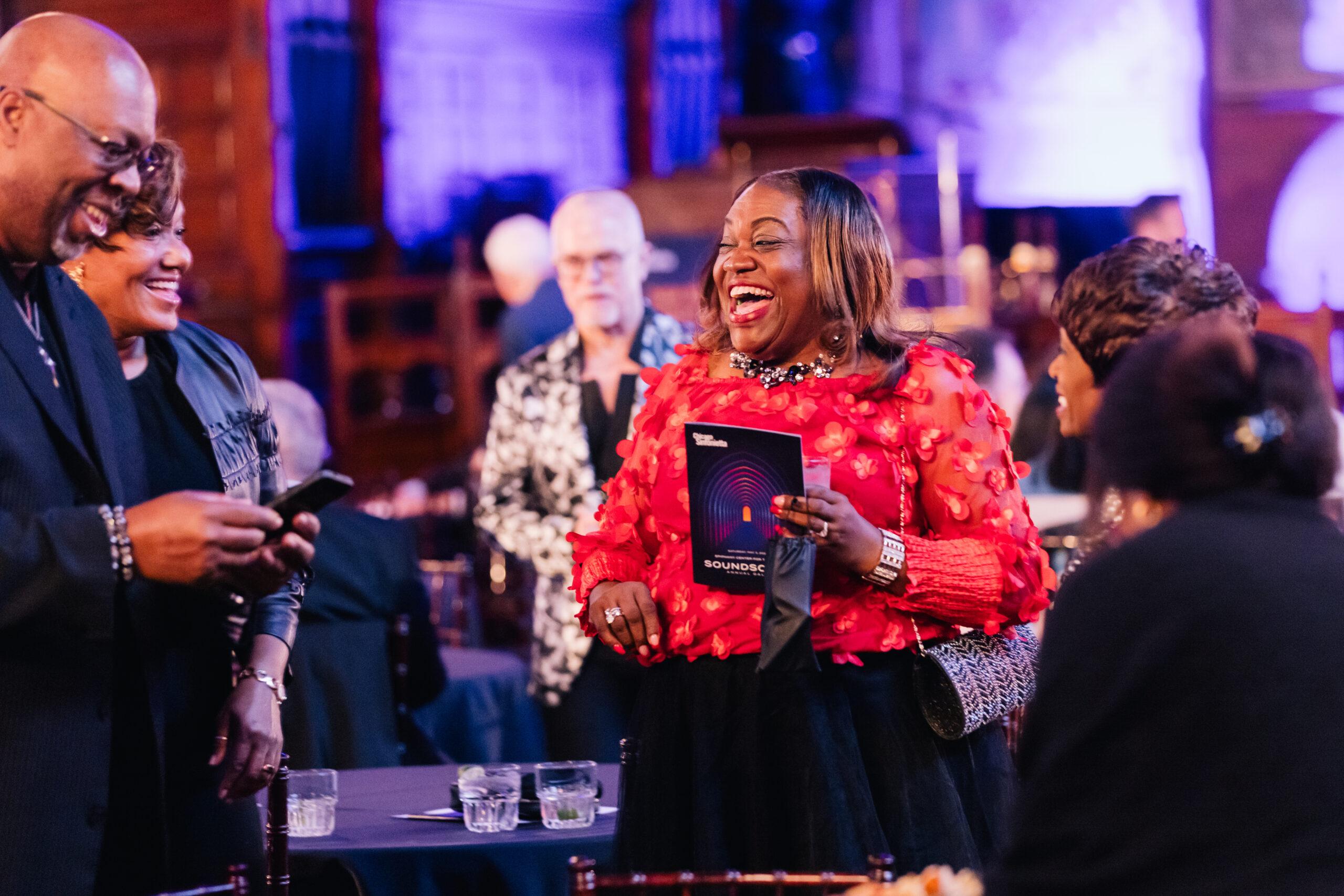 A woman in a red shirt laughing