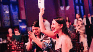 A woman raising an auction paddle