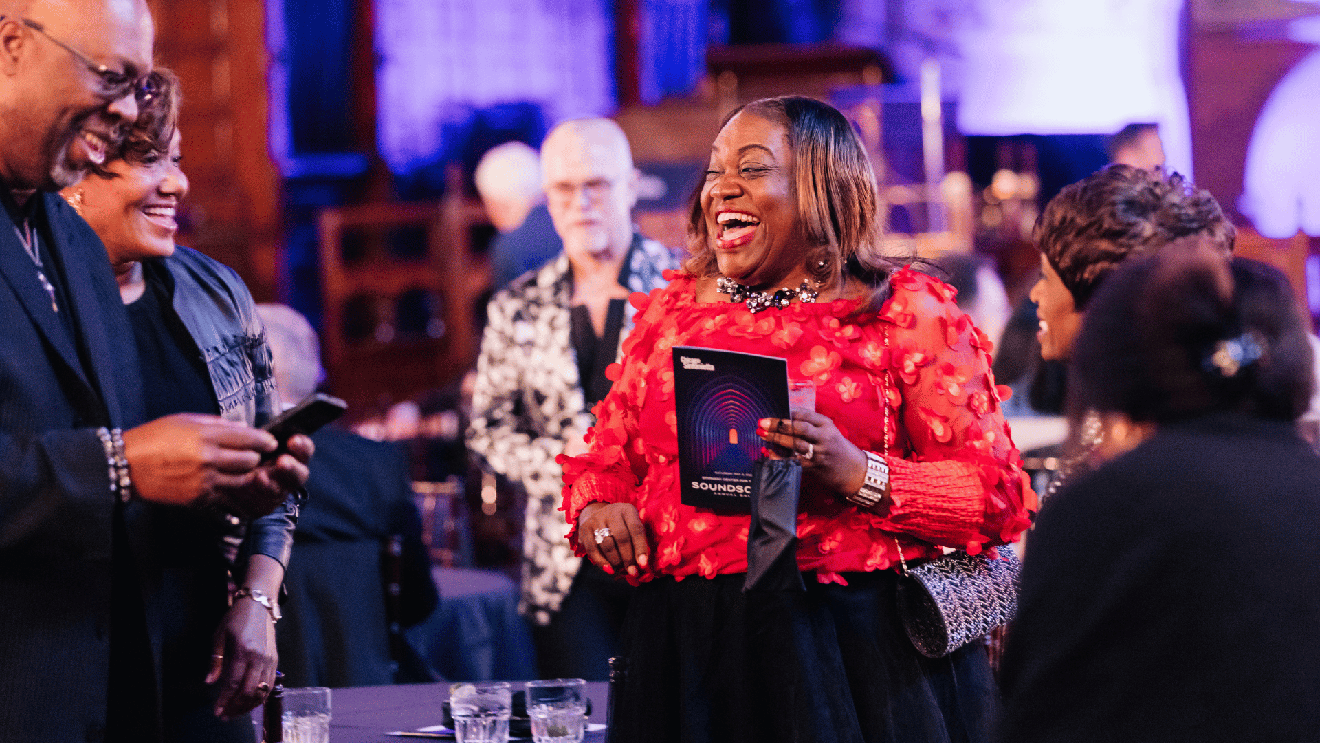 A woman in a red shirt laughing